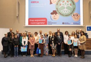 Fotografia finalistów 4. edycji konkursu genealogicznego „Bez korzeni nie zakwitniesz. Moja Mała i Wielka Ojczyzna” wraz z opiekunami naukowymi i rodzicami.Archiwum Narodowe w Krakowie, Aula im. dr. Sławomira Radonia, fot. Wojciech Staszkiewicz 